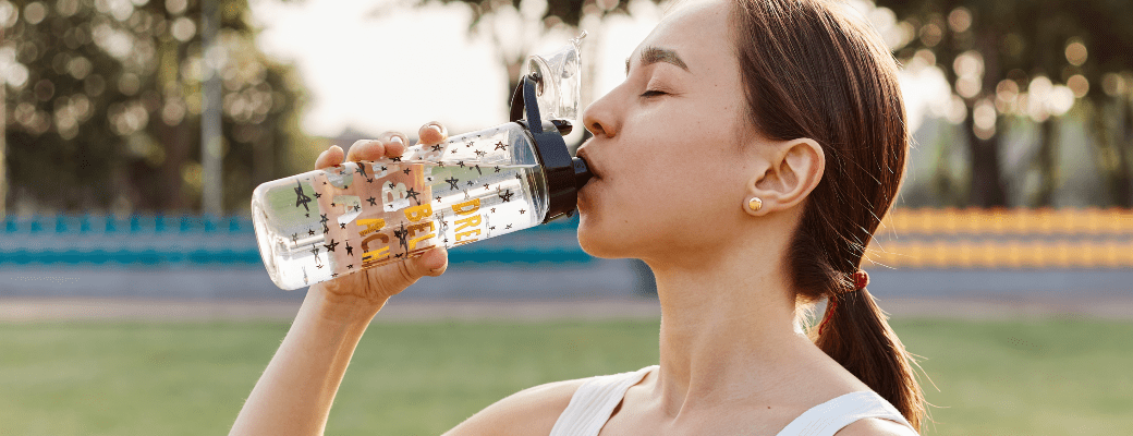 mujer hidratandose frente a golpe de calor