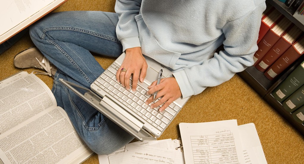 Adolescente estudiando con ordenador