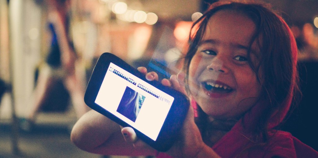 Niña con sus regalos tecnológicos en Navidad