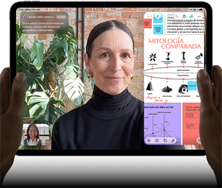 iPad Pro, parte delantera exterior, posición horizontal, color negro espacial, esquinas redondeadas, borde de la pantalla negro, dos manos sujetan los laterales izquierdo y derecho, la pantalla muestra una conversación de FaceTime con traducción en tiempo real y una app para aprender con una presentación sobre mitología comparada con texto, diagramas y notas escritas a mano