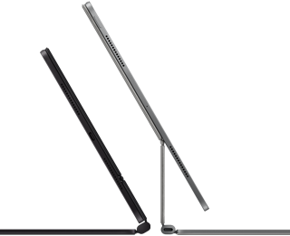Dos iPad Pro acoplados al Magic Keyboard, lateral exterior, diseño ultrafino, color negro espacial con altavoces y el conector USB-C, uno semiabierto, color plata, otro abierto, inclinado hacia atrás para mostrar el diseño con apoyo flotante del teclado, los altavoces y el micrófono