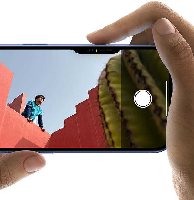 Unas manos sujetan un iPhone 16 que muestra el Control de Cámara. El dedo índice de la mano derecha se desliza por el lateral del teléfono para ajustar las opciones de la cámara.