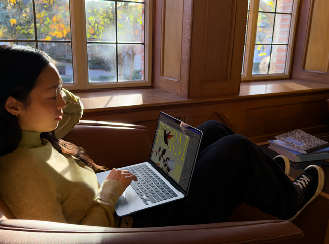 Una persona sentada en una butaca utiliza un MacBook Air